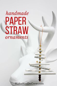 a handmade paper straw ornament hanging from a white deer's head