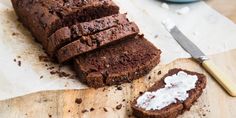 a loaf of chocolate bread sitting on top of a cutting board next to a knife