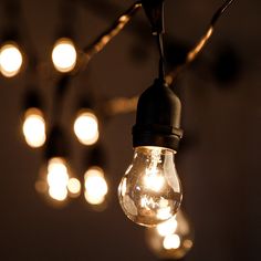 a bunch of light bulbs hanging from a chandelier in a dark room with lights on the ceiling