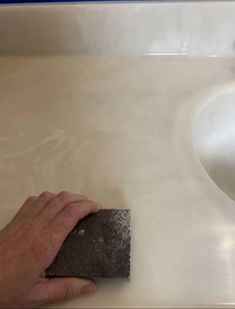 a person cleaning a sink with a sponge