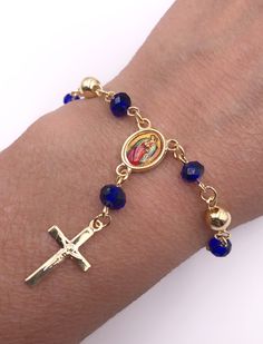 "Rosary Bracelet This is a minimalist and delicate 5mm 18k gold plated balls and 4mm royal blue crystal beads rosary bracelet. Lobster gold plated clasp for closure to make it easy to put it on by yourself. At the center hangs a beautiful colored Our Lady of Guadalupe gold plated medallion covered with a resin component that finish with a gold plated 2cm crucifix pendant. Perfect for everyday wear and could be perfect as a first communion, wedding or confirmation gift. Approximate length: 6.5\" Dainty Rosary Bracelet Gift, Dainty Rosary Bracelet Gift With Round Beads, Dainty 8mm Beads Jewelry Gift, Elegant Rosary Bracelet With Miraculous Medal, Dainty 8mm Bead Jewelry Gift, Dainty Yellow Gold Rosary Bracelet As Gift, Small Beaded Dainty Jewelry Gift, Elegant Rosary Bracelet With Miraculous Medal Gift, Gold-plated Rosary Bracelet For Gift