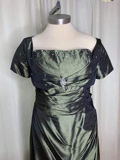 a green dress on a mannequin head stand