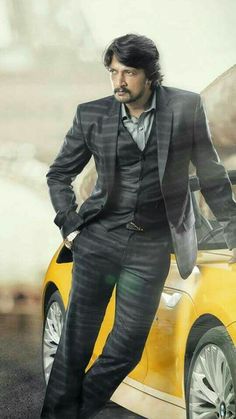 a man in a suit standing next to a yellow car