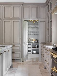 a large kitchen with white cabinets and gold trim