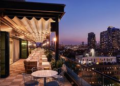 an outdoor dining area overlooking the city at night