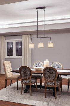 a dinning room table with chairs and a chandelier hanging from the ceiling