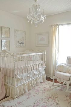 a baby's room with a crib, rocking chair and chandelier