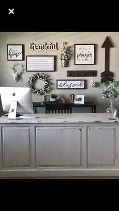 a desk with a computer on top of it next to some flowers and other decorations