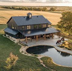 an aerial view of a house with a horse in the yard next to it and a pond