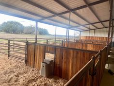 the inside of a barn with horses in it and stalls for them to be kept