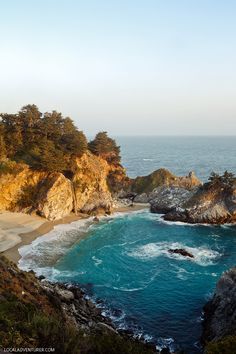 the beach is surrounded by rocks and water