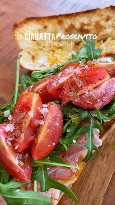 a sandwich with tomatoes, lettuce and ham