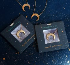 two necklaces with the moon and crescent on them, sitting next to each other