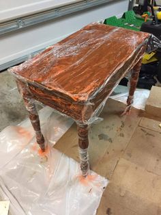 an old wooden table is covered in plastic