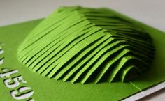 green folded business card sitting on top of a white table