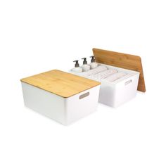 two white containers with soap and lotion in them next to a wooden cutting board