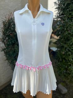 Here is a vintage 1970s Polyester tennis dress. Made by Kim Morgen. Size 9-10. Bust 32",waist 32", length measured from top of shoulder down to hem 28". Zips up the front. Cute pink trim with a pleated skirt.Has a line pull on one side. Very nice vintage condition. Fitted White Tennis Dress With Short Sleeves, White Fitted Vintage Dress, Fitted Knee-length Tennis Dress For Spring, Fitted Pleated Vintage Dress, Fitted Pleated Skirted Dresses, Fitted Pleated Vintage Summer Dress, White Mini Vintage Dress, Vintage Pleated Summer Dress, Vintage Summer Dress With Pleated Skirt