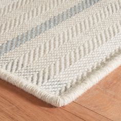 a close up view of a rug on the floor with wood floors and white carpet