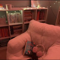 a chair with a book and some books on top of it in front of a book shelf