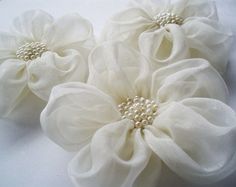 three large white flowers with pearls on them