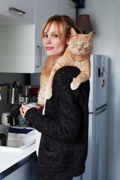 a woman holding an orange cat in her arms