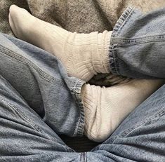 a person wearing blue jeans and white socks