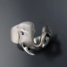 Sterling Silver Elephant Ring. This elephant is holding onto his best friend's trunk, making it a Friendship Ring! Did you know that Asian Elephants have been observed comforting one another when distressed. They use both physical contact and vocal sounds as forms of comfort, stroking one another with their trunks and emitting small chirps. The Elephant has dramatic textured satin finish with polished highlights and a bright Sapphire Blue eye. As each Elephant Ring is handmade. Please allow 2 to Asian Elephants, Sapphire Eyes, Owl Ring, Friendship Ring, Elephant Ring, Physical Contact, Elephant Jewelry, Silver Elephant, Asian Elephant