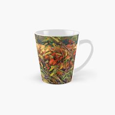 a tall mug filled with lots of different colored flowers and plants on the side of it