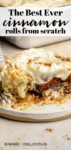 the best ever cinnamon rolls from scratch on a white plate with a fork in it