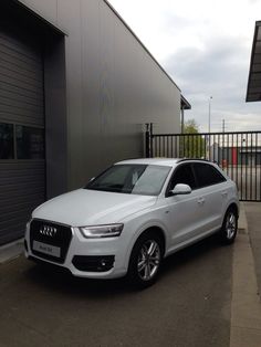 a white car parked in front of a building