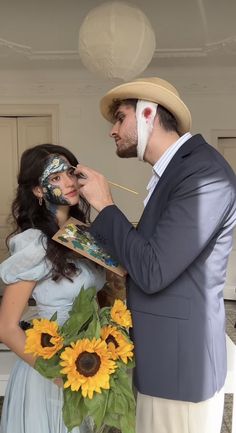 a man and woman are dressed up in costumes with sunflowers on their face