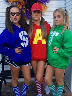 three girls dressed up in costumes posing for the camera