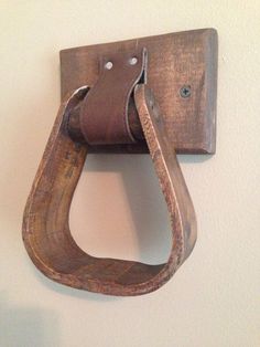 a wooden hook with a leather strap hanging from it's side on a wall