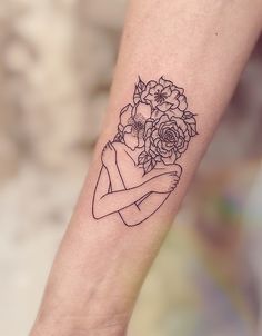 a woman's arm with a flower tattoo on it