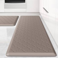 two bath mats sitting on top of a bathroom floor next to a sink and oven