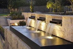 an outdoor water feature with lights on it