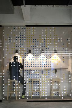 a man sitting at a table in front of a window with polka dots on it