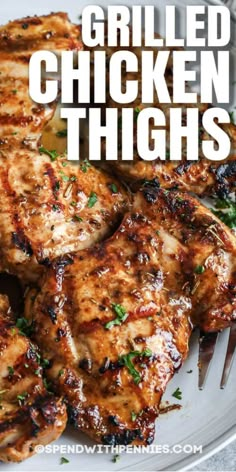 grilled chicken thighs on a white plate with a fork in the foreground and text overlay that reads grilled chicken thighs