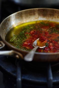 a pan filled with soup sitting on top of a stove