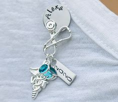 "Custom made pin for pinning ceremonies for an RN, NP, MA, LPN, LVN, BSN, SLP, DNP, PA, PTA, OTA, FNP, RT, PT, DPT, DNP, CNA, ADN, MD, and many many more! This beautiful shaped brooch/pin made with very unique design Hanging from the bottom is a VT caduceus charm and a birthstone charm with a disc hand stamped with the name of your choice. These pin it self is about 1 & 1/2 inch long but i did i hung charm on it so it will be about 2&1/2 inch after finished . Makes a great graduation gif Personalized Silver Lapel Pin For Gift, Personalized Silver Lapel Pin As Gift, Personalized Silver Lapel Pin Gift, Personalized Silver Pins For Anniversary, Pinning Ceremony, Vet Tech Gifts, Nursing Pins, Medical Jewelry, Tech Gift