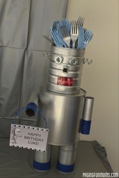 a birthday cake made to look like a robot with forks and spoons in it