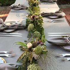 a long table is set with flowers and silverware