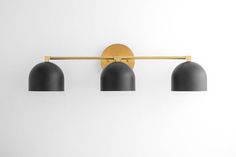 three black lamps mounted on a white wall