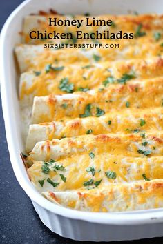 a casserole dish filled with cheese and green garnish on the side