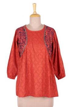 Evoking the beauty of spring in Delhi this cotton top from India is designed by Shashi Seghal. Subtle motifs decorate this paprika top which is accented at the shoulders with floral embroidery and bead work. This dress is further accented on the back with floral lacework. Red Tunic Tops For Spring, Spring Cotton Embroidered Sleeve Top, Floral Embroidered Cotton Tops For Fall, Spring Long Sleeve Tops With Chikankari Embroidery, Fall Cotton Tops With Floral Embroidery, Cotton Tops With Chikankari Embroidery For Fall, Fall Cotton Tops With Chikankari Embroidery, Spring Tunic Blouse With Printed Motifs, Cotton Blouse With Embroidered Sleeves