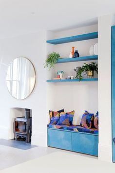 a living room filled with furniture and a blue book shelf next to a fire place