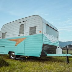 an old trailer is parked in the grass