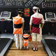 two people in costumes are walking on a treadmill and one is holding a child's hand