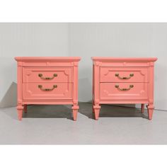 pair of pink nightstands with gold handles on each side, one has a drawer and the other has two drawers