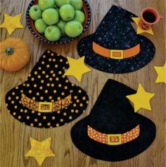 a wooden table topped with witches hats and pumpkins